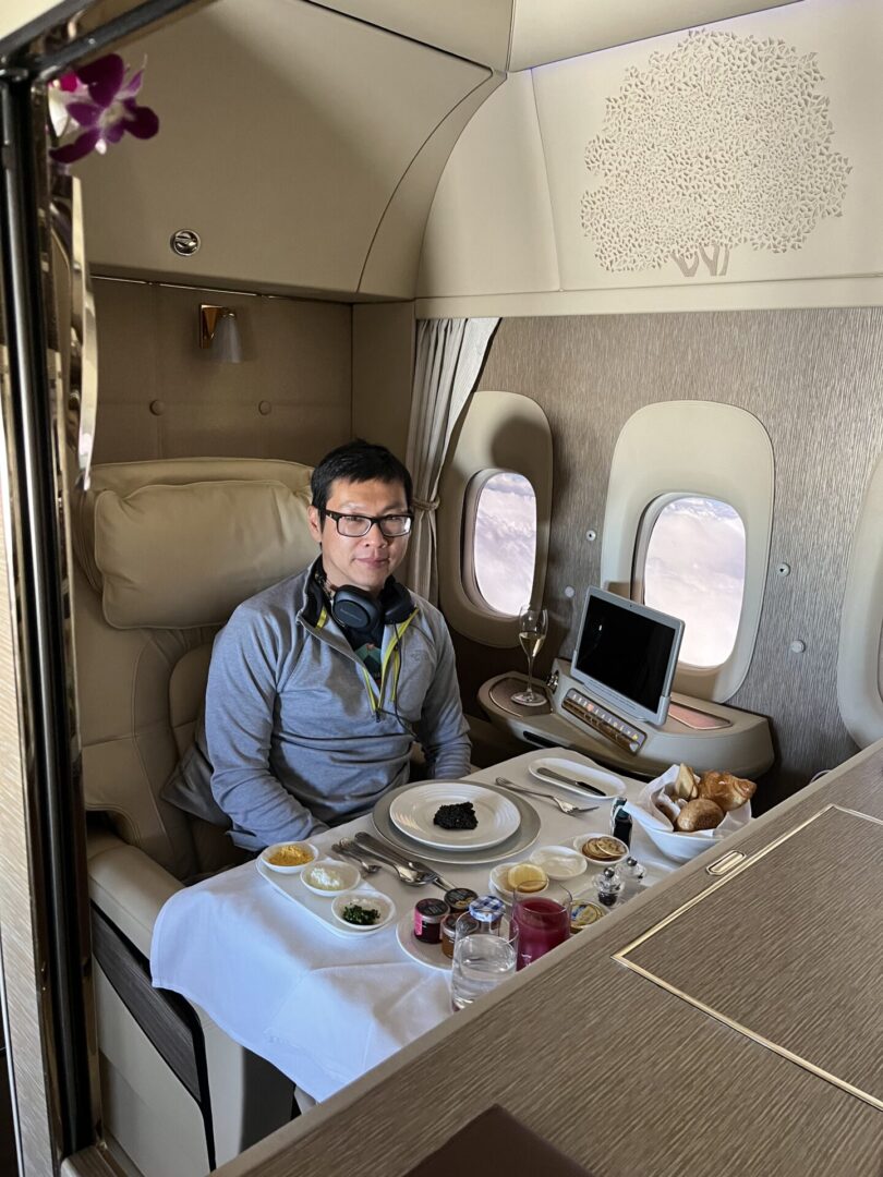 A man sitting at the table of an airplane.